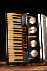 Accordion, old and beautiful accordion on rustic wood and dark background, selective focus.