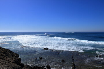 Stormy waves breaking on the stony beach in Fuerteventura in Jandia Natural Park