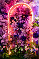 A large colorful flower arrangement reminiscent of a garden arch. The flowers are arranged in such...