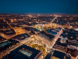 Aerial night cityscape about budapest downtown. Included the Ferris wheel, Erzsebet square, Deak square, Worosmarty square. View of illuminated streets.