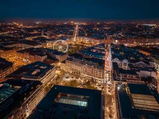 Aerial night cityscape about budapest downtown. Included the Ferris wheel, Erzsebet square, Deak square, Worosmarty square. View of illuminated streets.