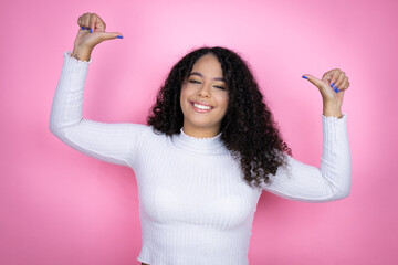 African american woman wearing casual sweater over pink background looking confident with smile on...