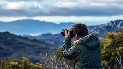A photographer is taking a picture of a beautiful mountain landscape. The sky is cloudy and the sun is shining through the clouds.