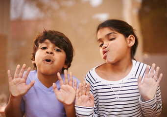 Window, face and funny siblings with kids press comic in a house with silly, joke or goofy gesture....