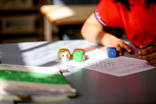 Closeup of dice and maths sheets