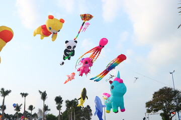 Colorful kites flying in the clear blue sky in sunny summer day at Mekong Delta Vietnam. Happy...