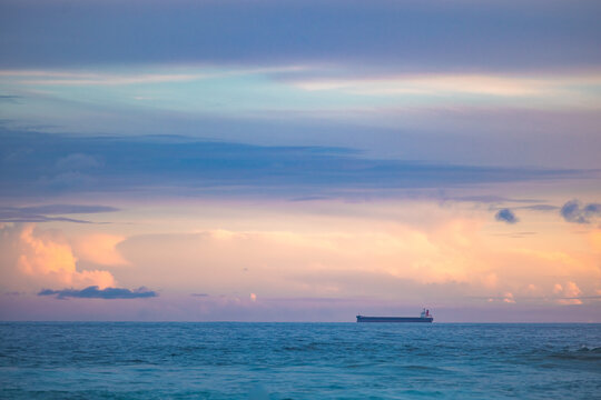 Cargo ship lined up at sea on their way to Newcastle Harbour under a vibrant sunset sky