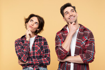Thoughtful couple, dreaming woman and a smiling man, crossing arms, looking away