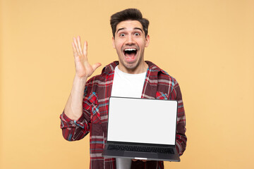 Shocked man gesticulating and shouting, demonstrating laptop with a blank screen, looking at camera