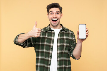 Photo of excited man holding mobile phone, showing empty screen, and making a thumb up gesture