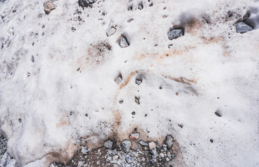 Stones after a rockfall fell into the snow in the highlands of the Tien Shan