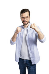 A young man in casual clothing and glasses, posing with fists raised on an isolated white background, conveying a confident emotion
