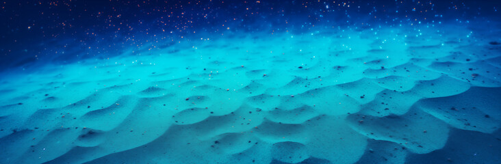 A blue ocean with sand and rocks