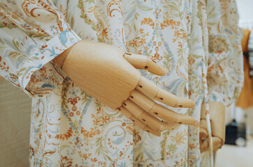 Fototapeta na wymiar Wooden hand of mannequin in female dress screenings. Image for beauty and fashion concept.