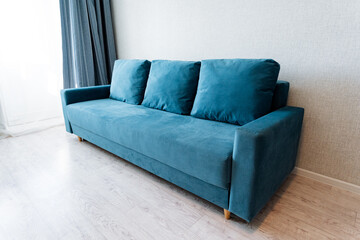Azure couch fixture in living room next to window, on hardwood floor