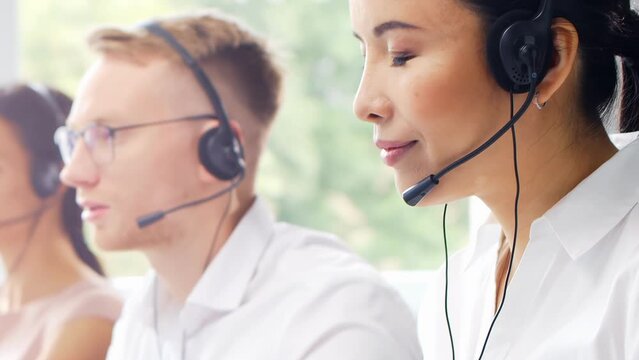 Diverse team of young professionals is working in the phone support office. Working day of sales managers in the call center. Business, telephone consulting and problem solving.