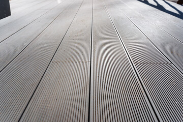 Closeup of grey hardwood flooring with diagonal pattern on wooden deck