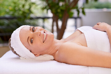 Obraz na płótnie Canvas Happy woman, portrait and relax with towel for spa, zen or massage table at hotel or outdoor resort. Face of female person with smile, enjoying facial or body treatment at accommodation for wellness