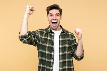 Portrait photo of a handsome man screaming and making a 'yes' gesture, celebrating a victory