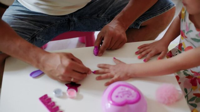 Daughter and father role-playing manicure salon