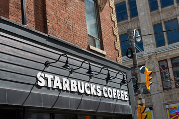 Fototapeta premium exterior building facade and sign of Starbucks Coffee located here at the north east corner of Queen and John in Toronto, Canada