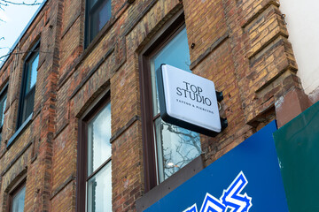 Fototapeta premium projecting sign of Top studio fine-line tattoo and piercing located at 265 Queen Street West in Toronto, Canada