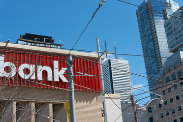 Fototapeta premium exterior building and sign (detail) of Scotiabank branch located at 222 Queen Street West in Toronto, Canada - BMO tower in Financial District behind