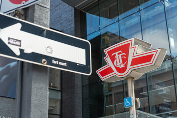 Fototapeta premium logo shaped light TTC sign (subway entrance marker) and one way street sign in Toronto, Canada