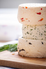 Several varieties of homemade cheese with different fillings with paprika, dill and olives on a wooden board - 765694743