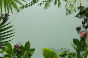 Composition made of meadow flowers and leaves on green background. Flat lay. View from above