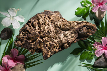 A wooden stand decorated with flowers, leaves and stones, used to display products and advertise.