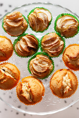 Delicious homemade vanilla muffins with sliced apple on the glass plate on white background. Sweet dessert for celebration, party or snack. Cupcakes. - 765696775