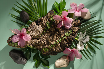 A wooden stand decorated with flowers, leaves and stones, used to display products and advertise.