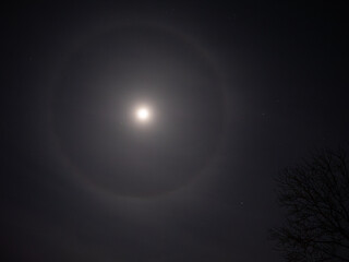 Naklejka na ściany i meble Cirrostratus - a circle around the moon is usually a harbinger of approaching rain, because it occurs at the top of a warm front. If it forms around the moon, it can start raining as early as morning.