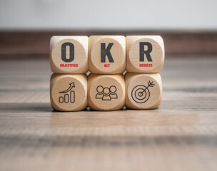 Cubes, dice or blocks with acronym OKR Objective key results on wodden background