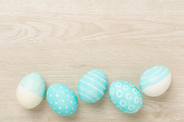 Blue easter eggs on wooden background, top view