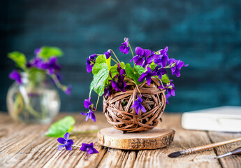 Rustic Violet Flowers in Basket on Wooden Table