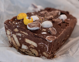 Close up of hand made Rocky Road chocolate dessert, with crushed mini Easter eggs digestive biscuits and marshmallows, for Easter celebrations. 