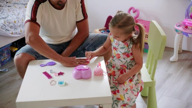 Daughter and father role-playing manicure salon