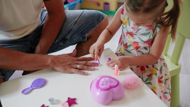 Daughter and father role-playing manicure salon