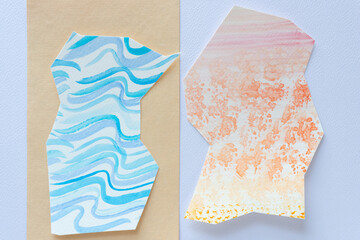 two abstract paper shapes with cut edges and each with brush textures on yellow and blank paper with texture