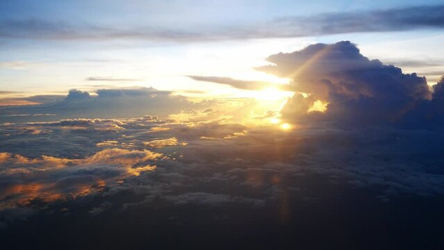 aerial view over cloudscape from airplane flying in sunset sky time with thick fog above the beautiful ocean of clouds in sundown.