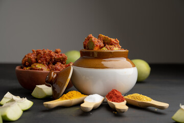 Homemade Mango Pickle or aam ka achar Kairi Loncha stored or preserved in China clay pot with...
