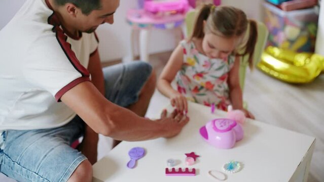 Daughter and father role-playing manicure salon