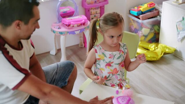 Daughter and father role-playing manicure salon