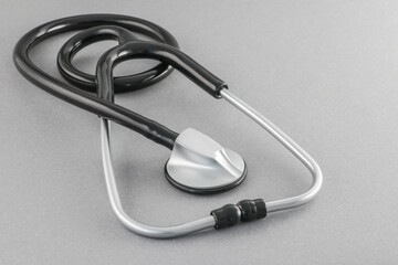 Black stethoscope on a gray background