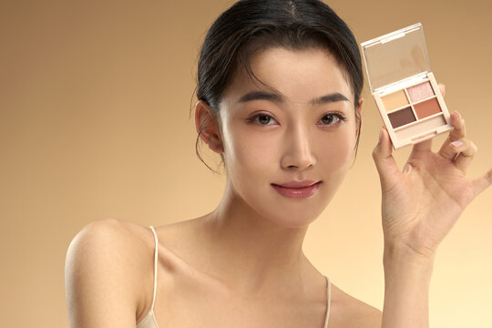 Young beauty with eye shadow box