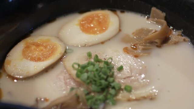 close up view to a bowl of traditional japanese style ramen or noodle with rich flavor broth