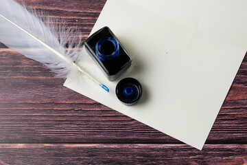Ink, feather on a table