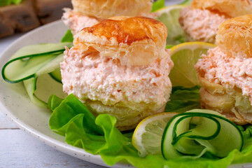 Smoked trout pate with cream cheese between puff pastry buns served on salad. Exquisite appetizer 